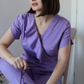 Bluză medicală elegantă Blooming Orchid cu design cu volane și mânecă lalea, lila, disponibilă la comandă la DR. BLA SCRUBS.